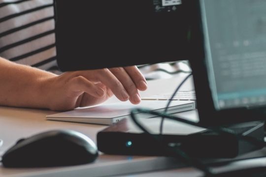 Klicken Sie, um das Bild zu bearbeiten Person tippt auf Tastatur