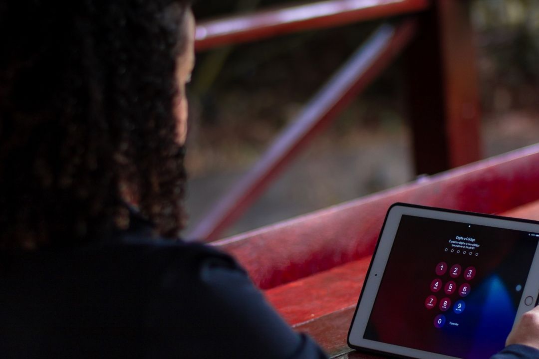 Person sitzt vor Tablet mit PIN zum Schutz für Smarte Geräte