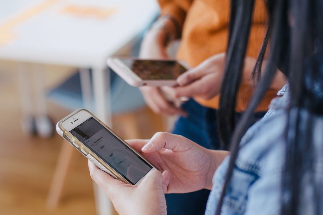 zwei Personen mit Handys in der Hand