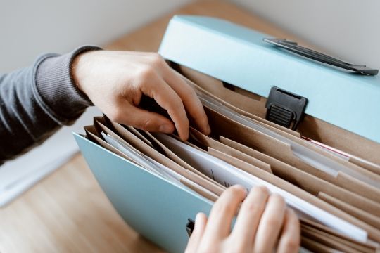 Klicken Sie, um das Bild zu bearbeiten Person durchsucht Ordner mit verschiedenen Fächern