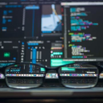 Brille vor Laptopbildschirm mit Code