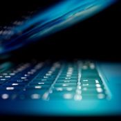 Halb aufgeklappter, blau beleuchteter Laptop