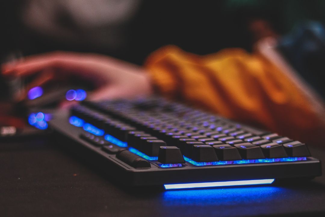 leuchtende Tastatur mit Arm im Hintergrund