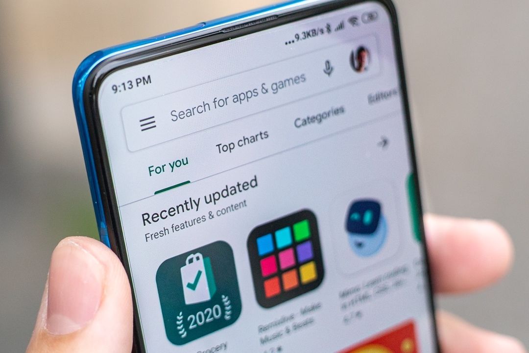 Person hält Handy mit geöffnetem Playstore