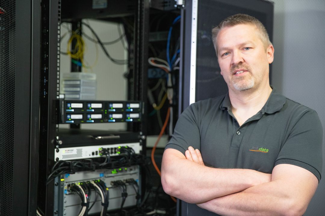 mit.data Mitarbeiter neben Serverschrank