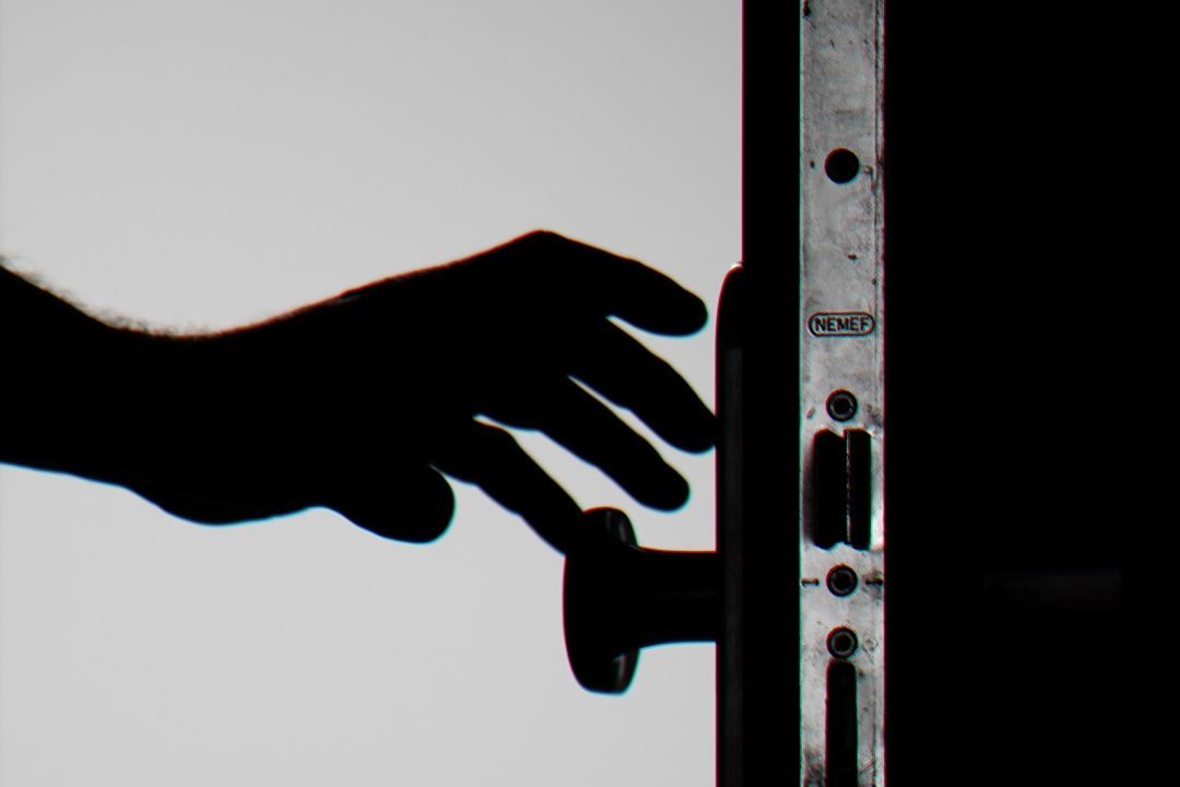 Hand an Türklinke in schwarz-weiß