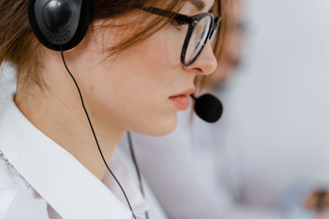 Frau mit Headset telefoniert über eine Unified Communications Lösung